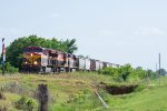 A northbound grain train approaches a small crossing